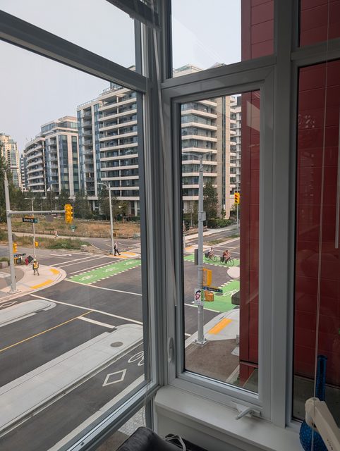Open casement window in a high-rise looking down over the street