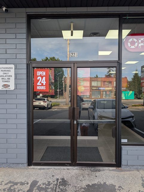 Aluminum storefront double doors glazed and lit at night