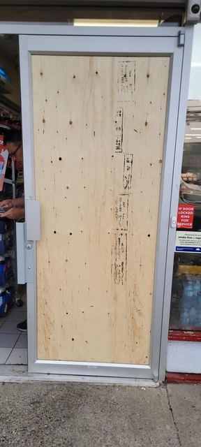 Plywood board-up securing a storefront door