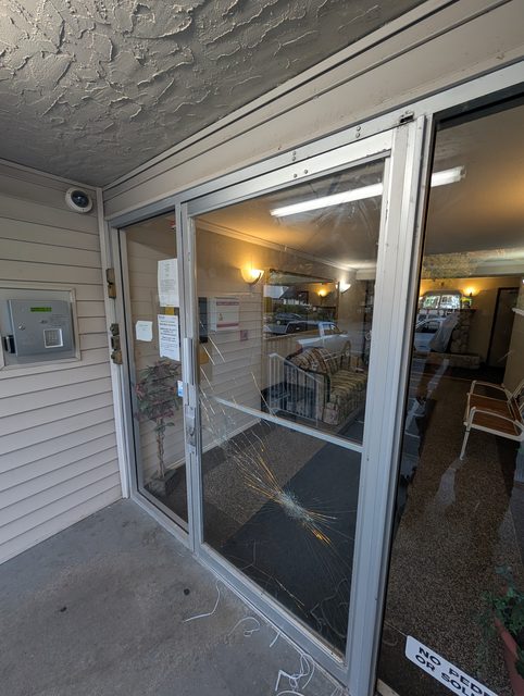 Apartment lobby door with shattered glass before emergency replacement