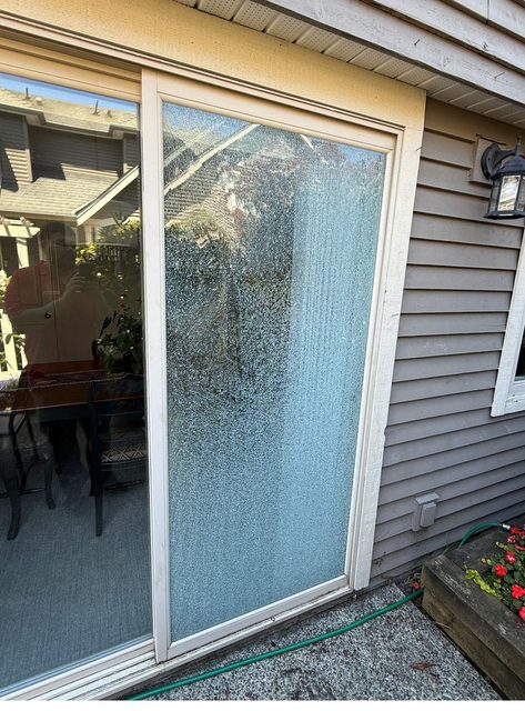 Shattered tempered glass in a sliding patio door before emergency replacement