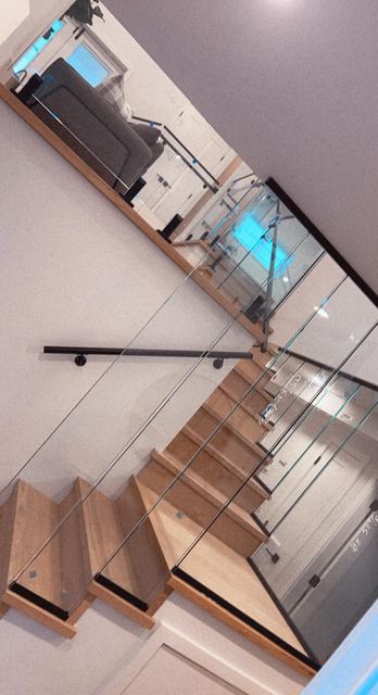 Glass railing along a dark wood staircase