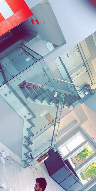 Glass stair railings with stainless standoffs during installation