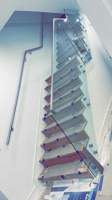 Glass stair railing looking down the stairwell