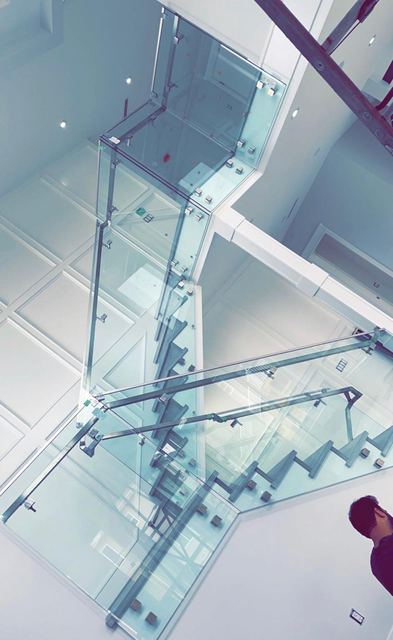 Frameless glass railings on a bright stairwell