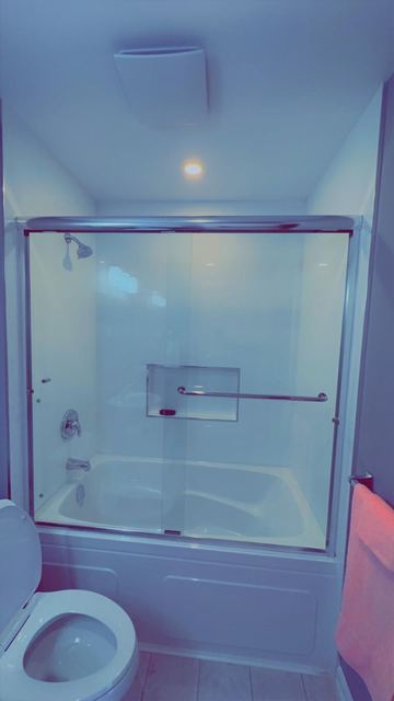 Framed glass shower enclosure in brushed nickel