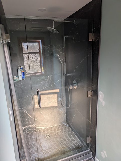 Interior view of a frameless dark marble shower enclosure