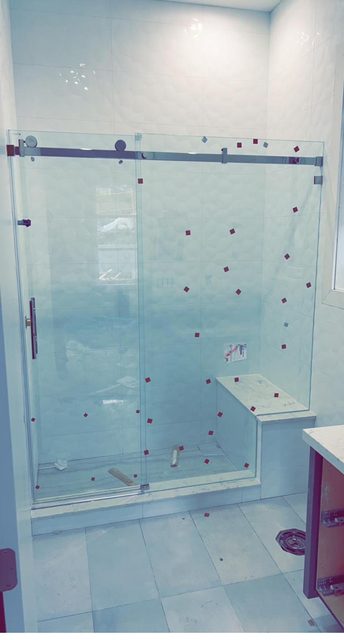 Frameless sliding shower door with a built-in bench seat