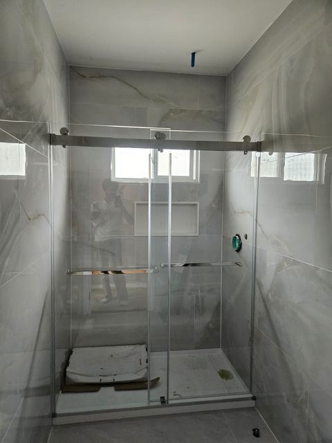 Sliding shower door with silver hardware