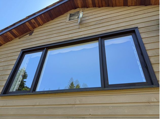 Black-frame picture windows after glass replacement, seen from outside