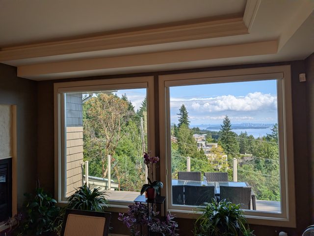 Corner living room windows with an ocean view after reglazing