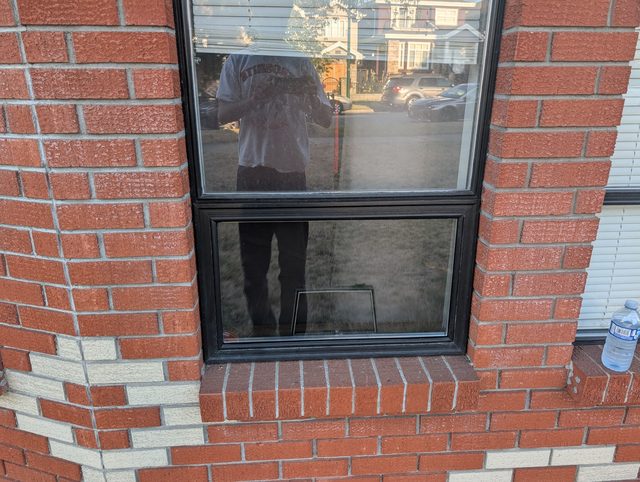 Cracked window pane in a red brick apartment building